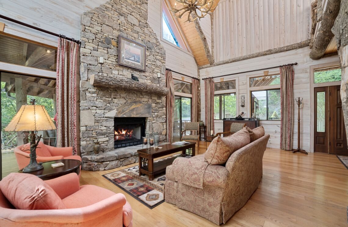 Great room and stone fireplace opening onto the covered deck