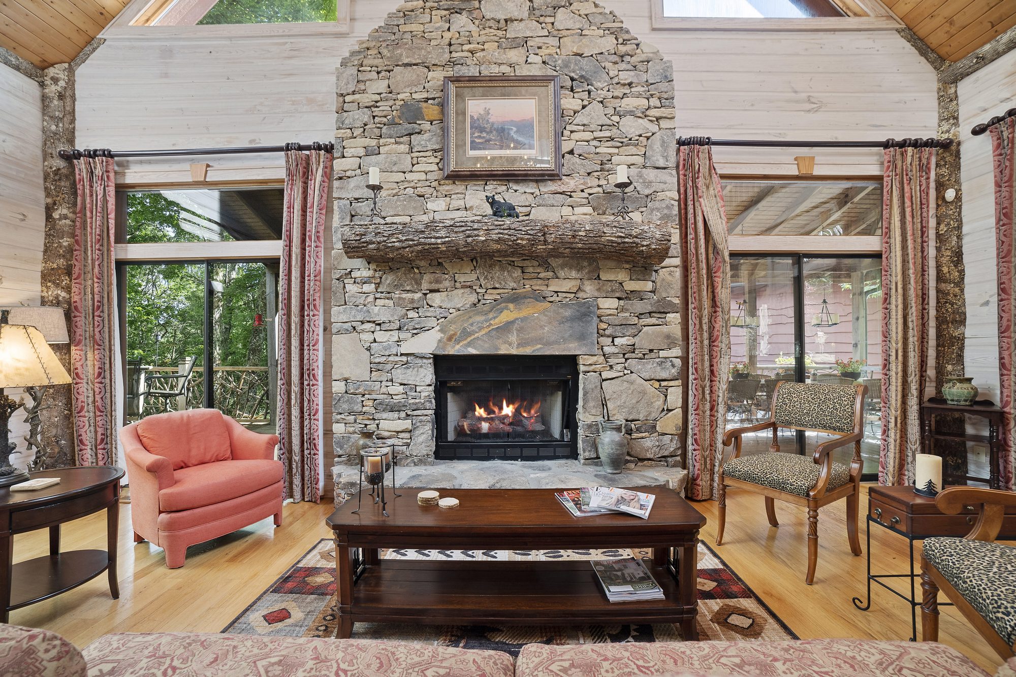 Great room with floor-to-ceiling stone fireplace and log beams