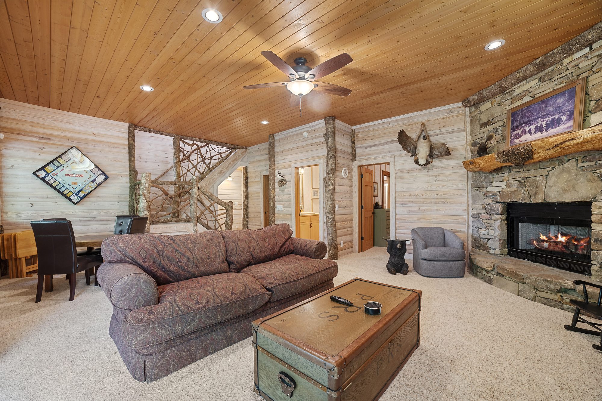 Lower-level den with second stone fireplace and game table